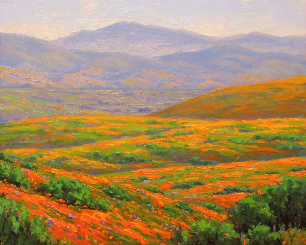Vibrant orange and green hills under a soft, cloudy sky.