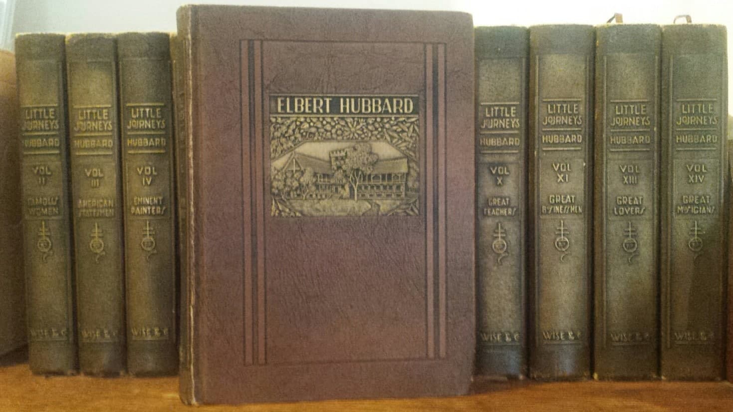 A collection of vintage books titled "Little Journeys" by Elbert Hubbard, featuring one prominently displayed in the center.