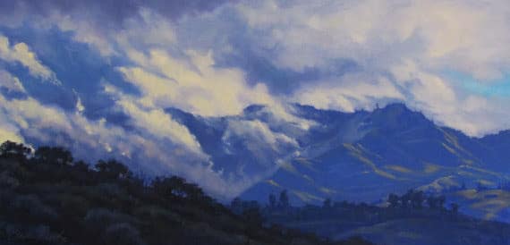 A serene mountain landscape with rolling hills and dramatic, cloud-filled skies.
