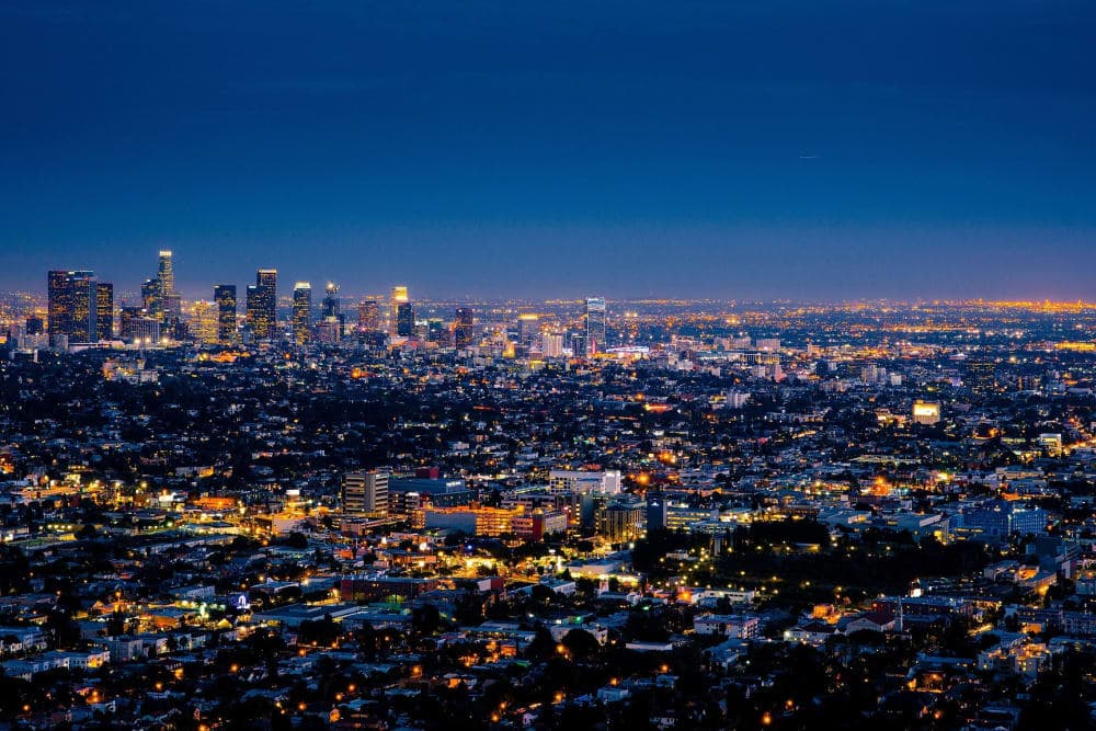 Aerial view of a bustling Los Angeles skyline illuminated at dusk.
